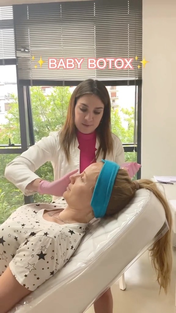 La Dra. Moyano aplica baby botox a una paciente recostada, junto al ventanal del consultorio